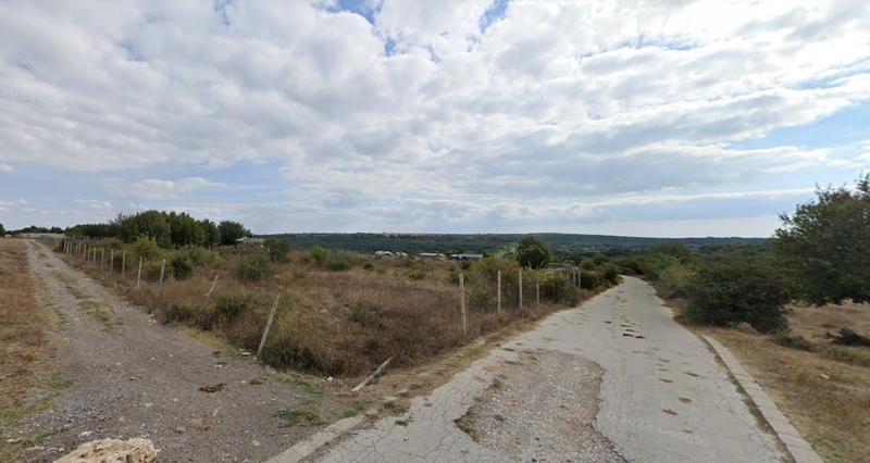 Flat fenced plot of land with square shape on asphalt road Flat fenced plot of land with square shape on asphalt road