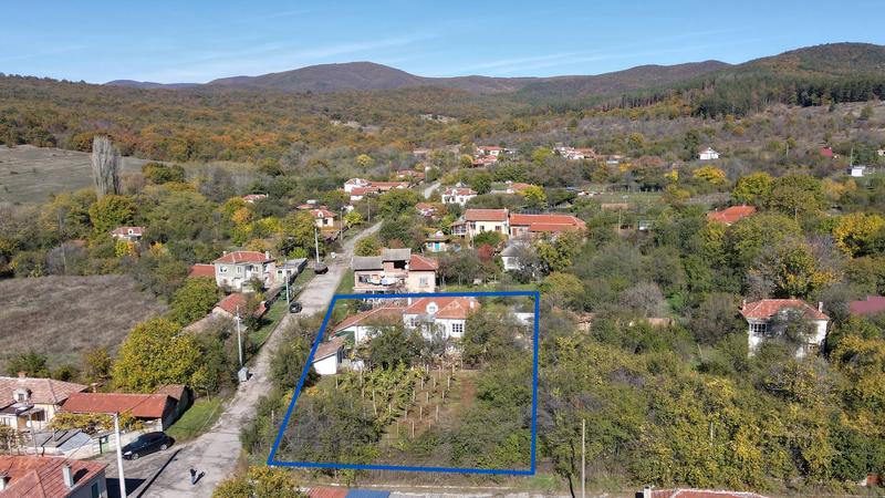 Two-storey house with a well-maintained garden and stone fence